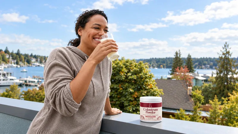 An adult enjoying a drink beside an IYRA tub on a bright waterfront balcony